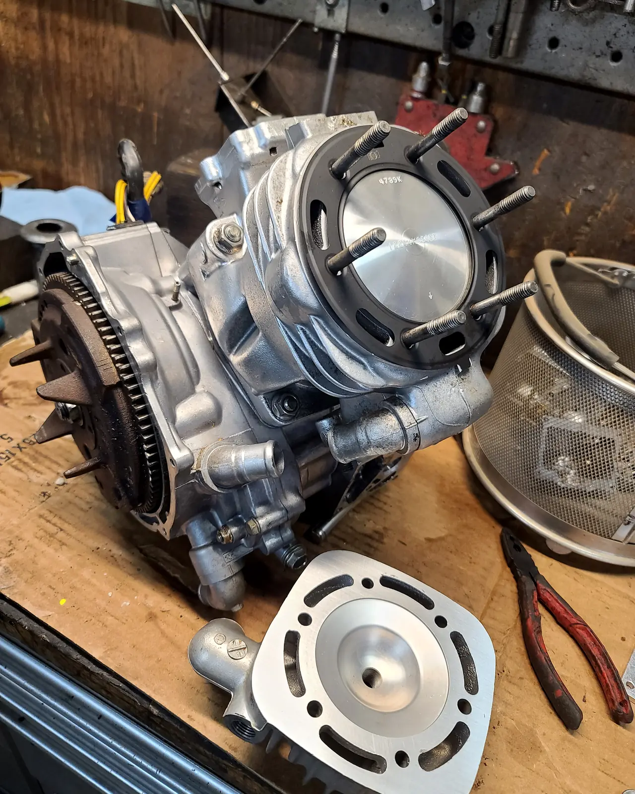Reassembled Polaris 2-stroke top end beside a freshly machined cylinder on the workbench