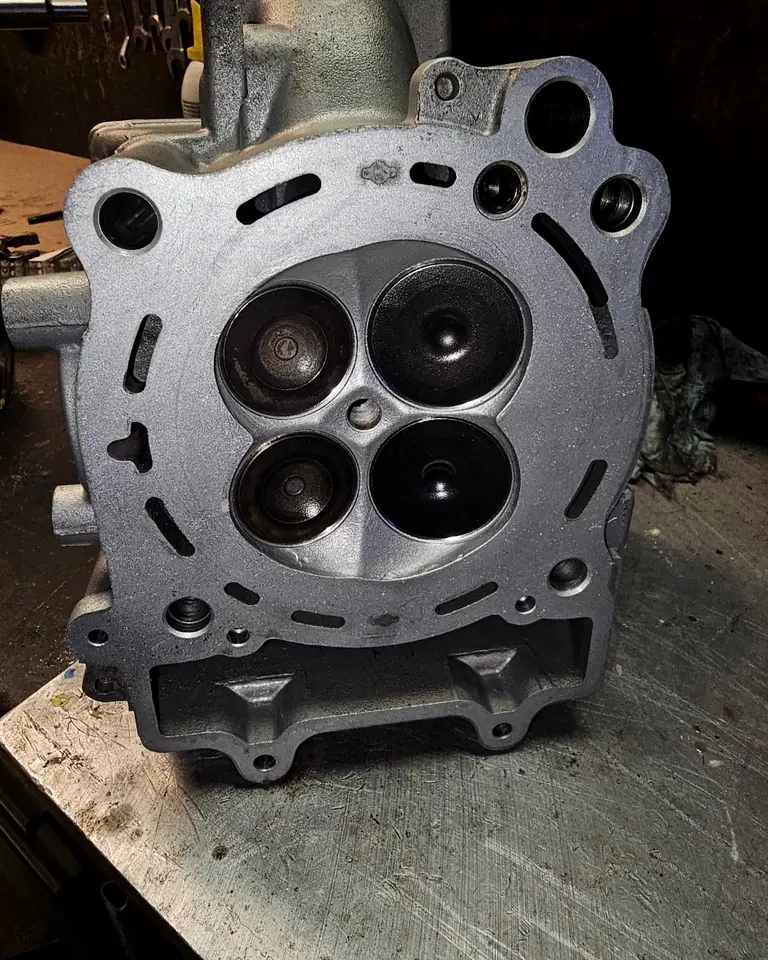 Polaris 570 four-valve cylinder head during engine service, combustion chamber and valve faces exposed