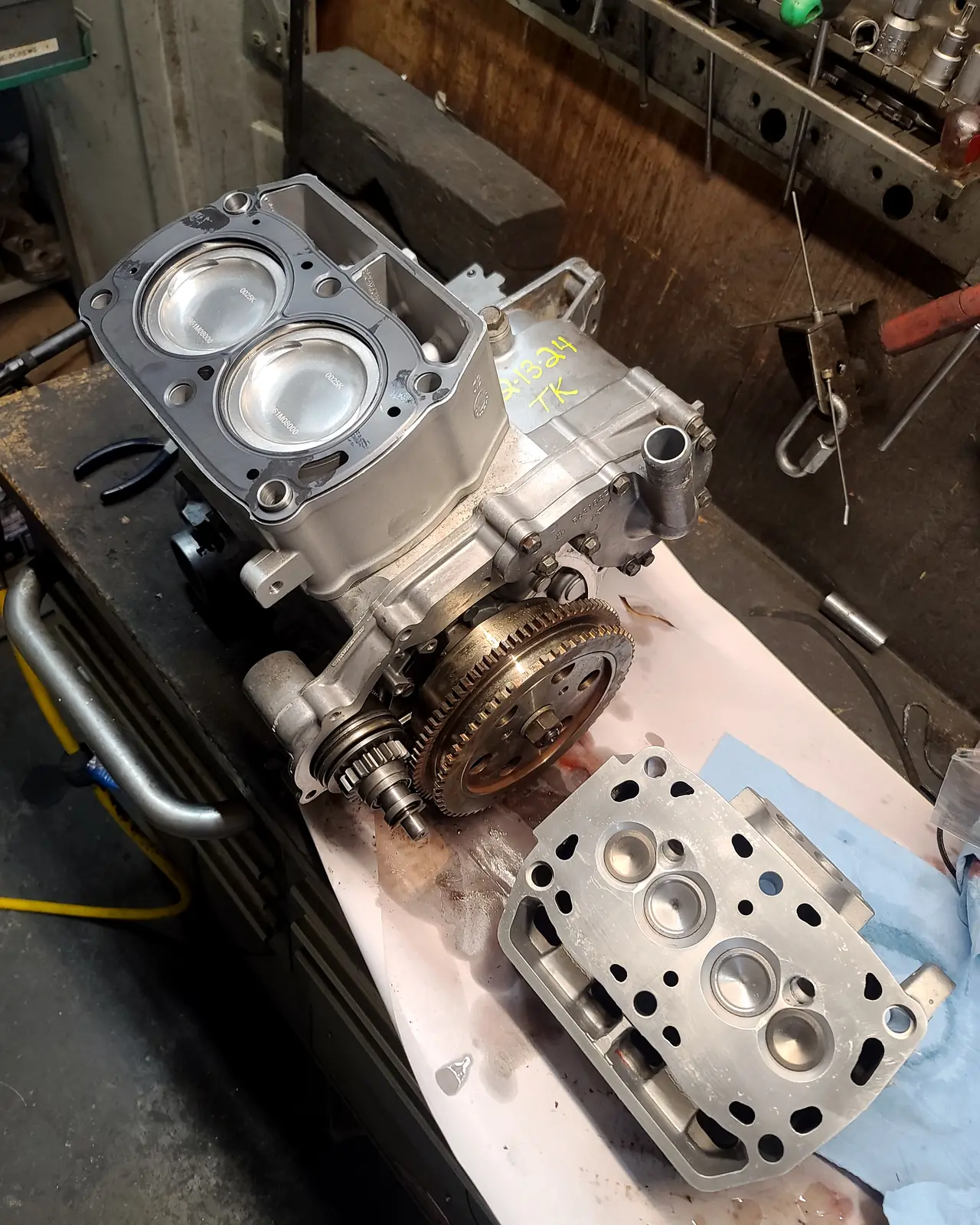 Polaris engine case with two fresh pistons fitted and the machined head laid out beside it