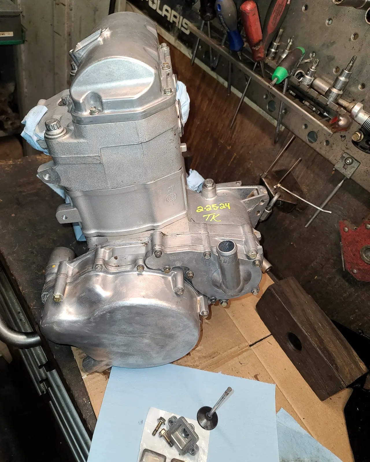 Rebuilt Polaris engine on the workbench beneath the Polaris shop sign