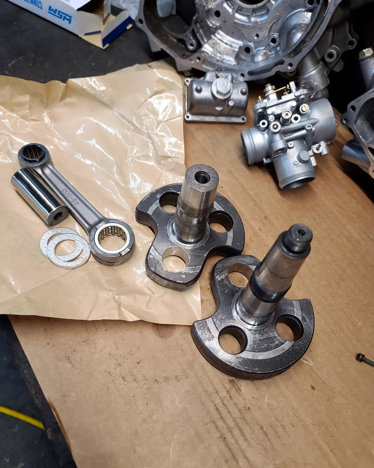 Polaris front spindles, wheel hubs and a connecting rod laid out on brown paper