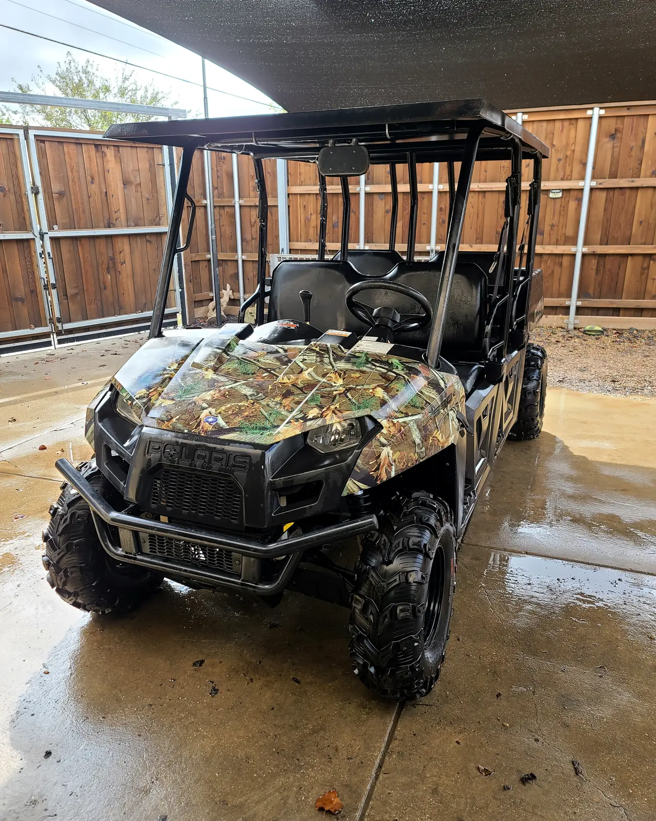 Camouflage-wrapped Polaris Ranger Crew parked outside the shop after service